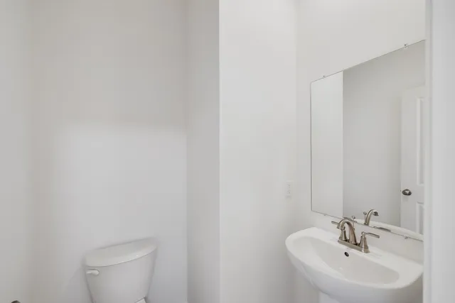 a bathroom with a sink a toilet and mirror
