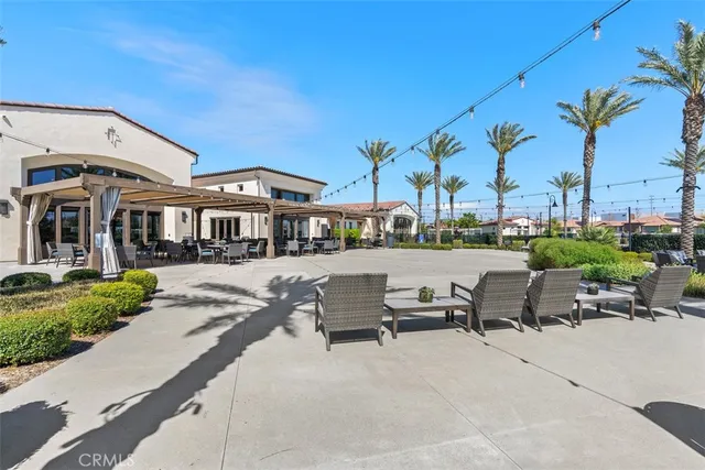 a view of swimming pool with outdoor seating and palm tree