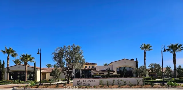 a view of a patio with table and chairs under an umbrella with potted plants