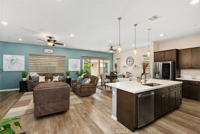a living room with furniture kitchen view and a flat screen tv