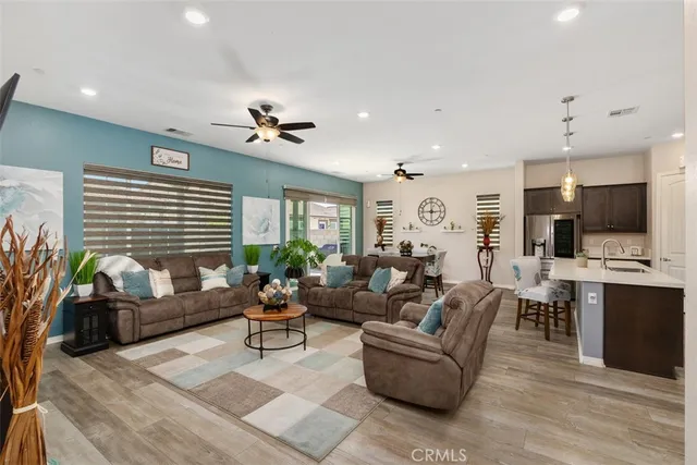 a living room with furniture kitchen view and a chandelier