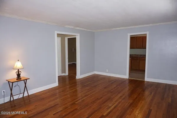 a view of empty room with wooden floor