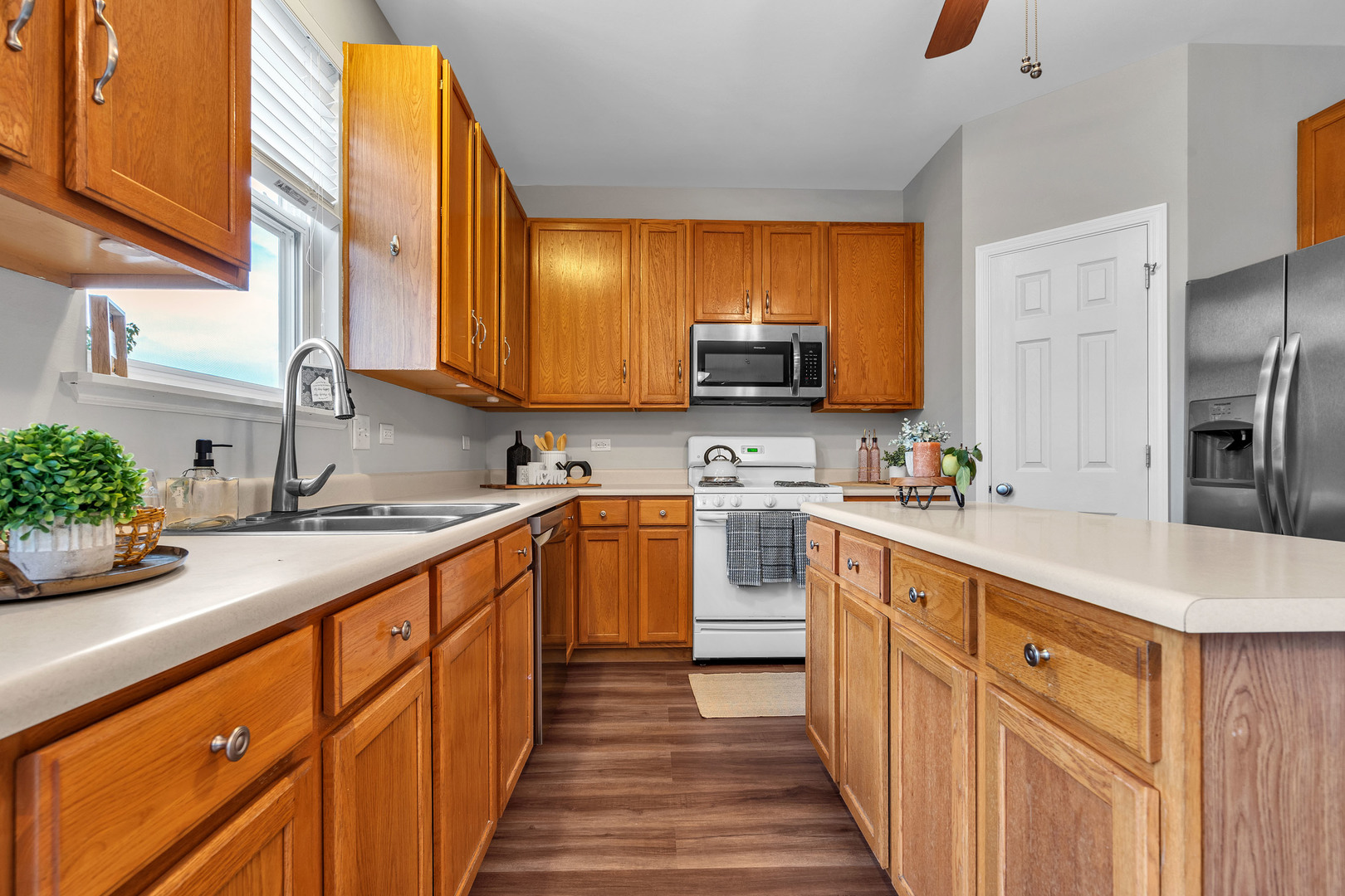2513 Simon Drive Montgomery, IL 60538 - Photo 12 of 33 a kitchen with stainless steel appliances a sink dishwasher a refrigerator and a stove with wooden floor