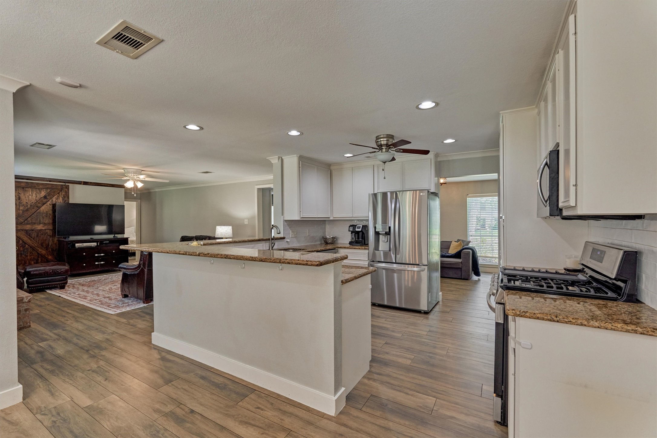 6515 Glenhill Drive Spring, TX 77389 - Photo 10 of 39 a kitchen with stainless steel appliances kitchen island granite countertop a stove and a refrigerator