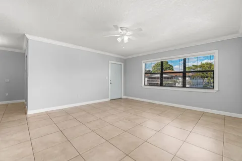 an empty room with windows and ceiling fan