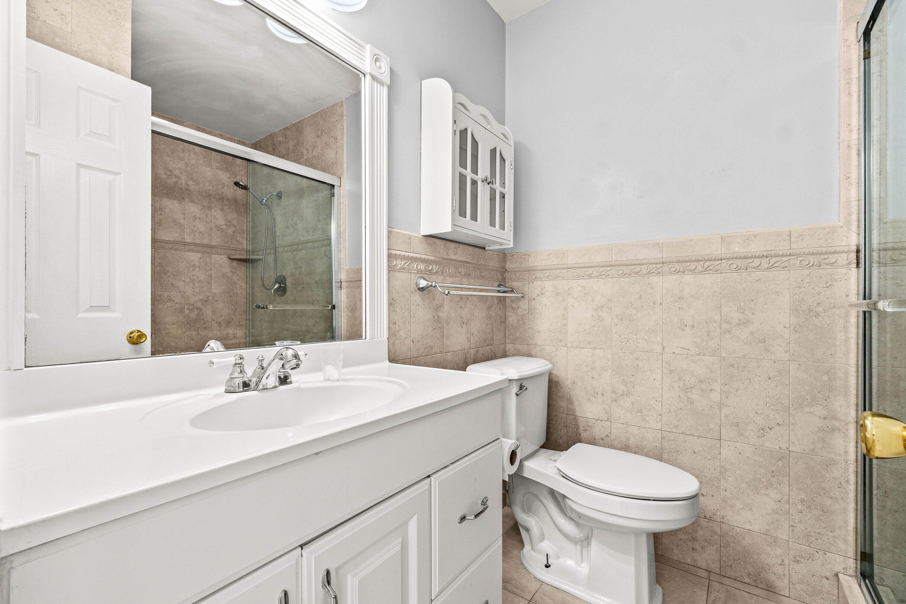 200 Southwest 7th Street, Unit 3 Boca Raton, FL 33432 - Photo 19 of 35 a bathroom with a sink a toilet and shower