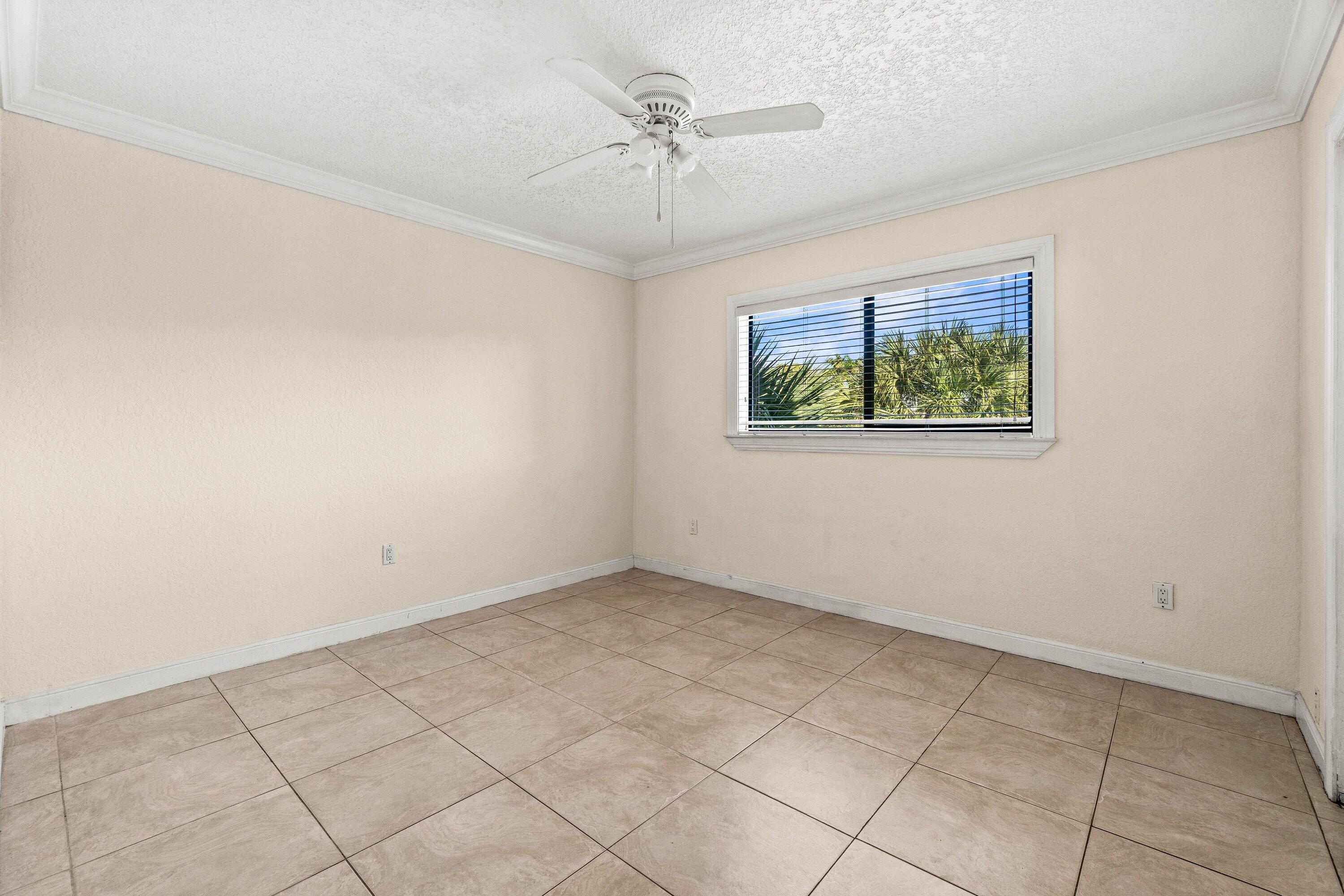 200 Southwest 7th Street, Unit 3 Boca Raton, FL 33432 - Photo 22 of 35 an empty room with windows and ceiling fan