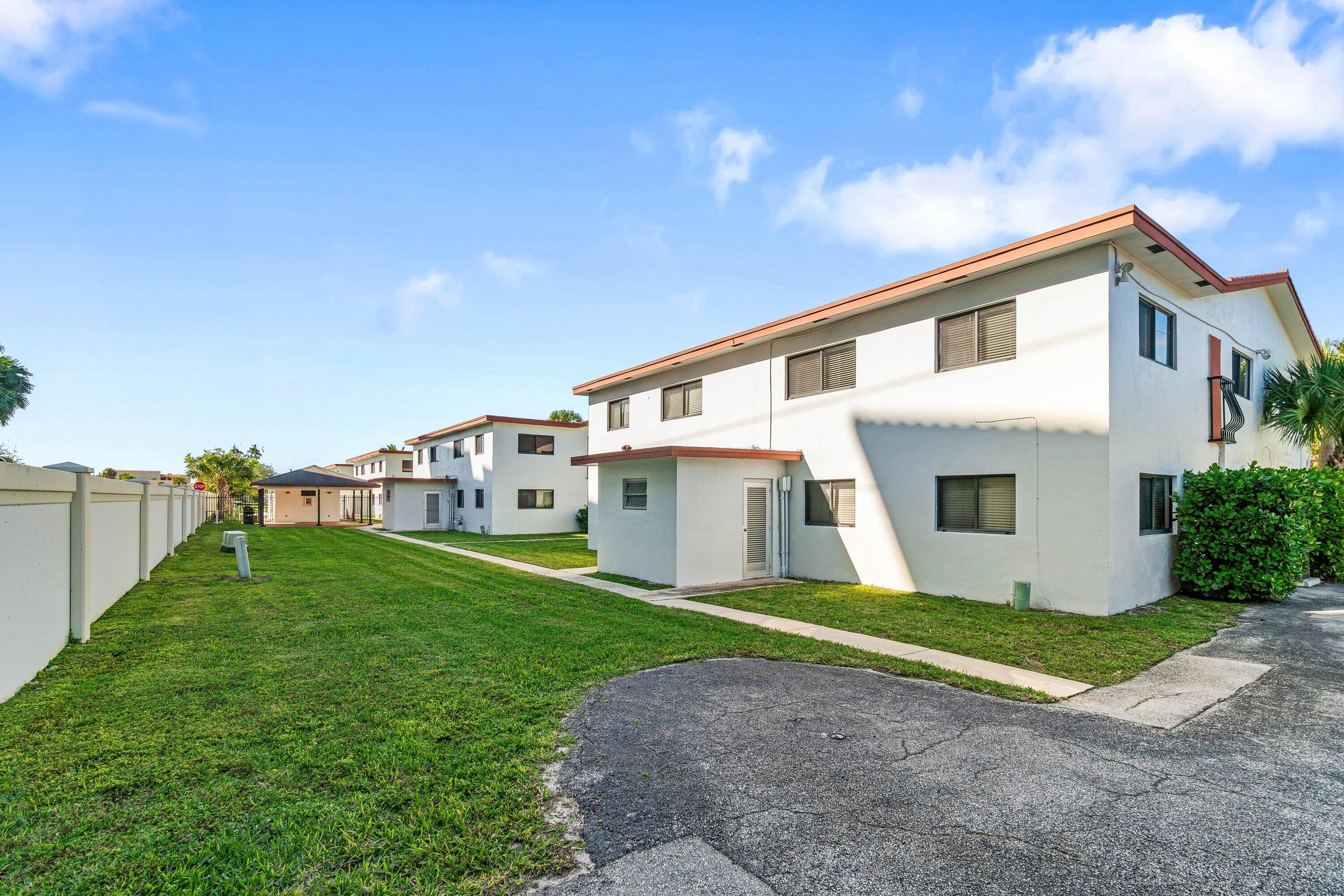 200 Southwest 7th Street, Unit 3 Boca Raton, FL 33432 - Photo 25 of 35 a front view of a house with a garden and yard