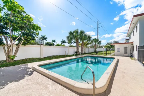 a view of a swimming pool with a patio and a yard