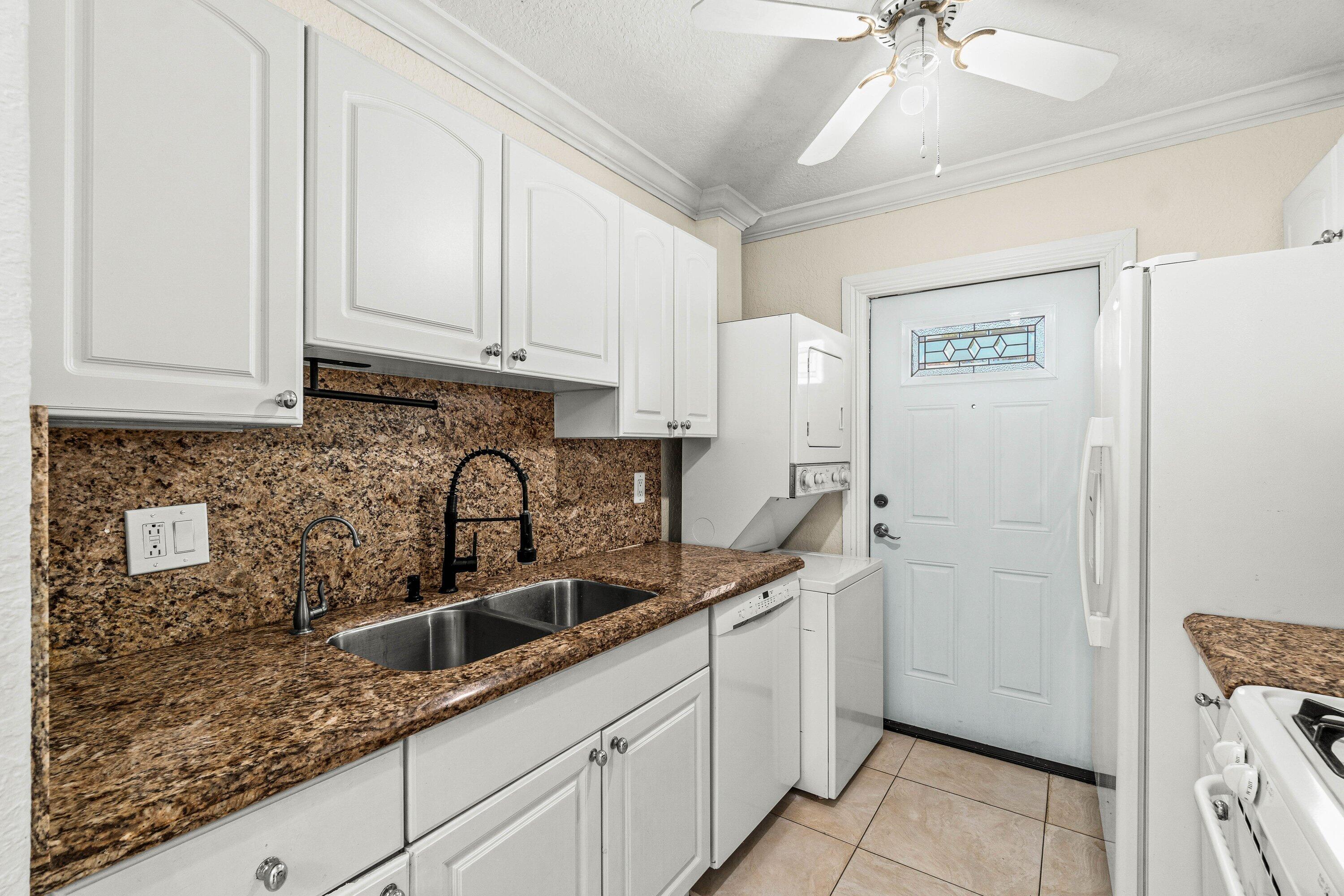 200 Southwest 7th Street, Unit 3 Boca Raton, FL 33432 - Photo 5 of 35 a kitchen with stainless steel appliances granite countertop a sink a refrigerator and cabinets