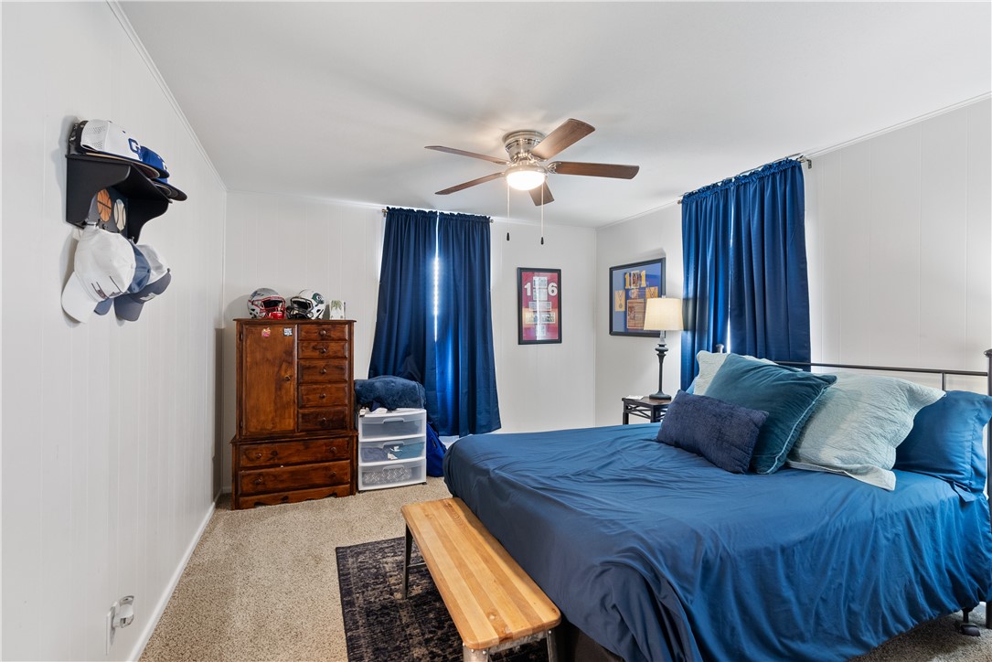 1204 Fannin Street George West, TX 78022 - Photo 14 of 24 a bedroom with a bed and dresser with wooden floor