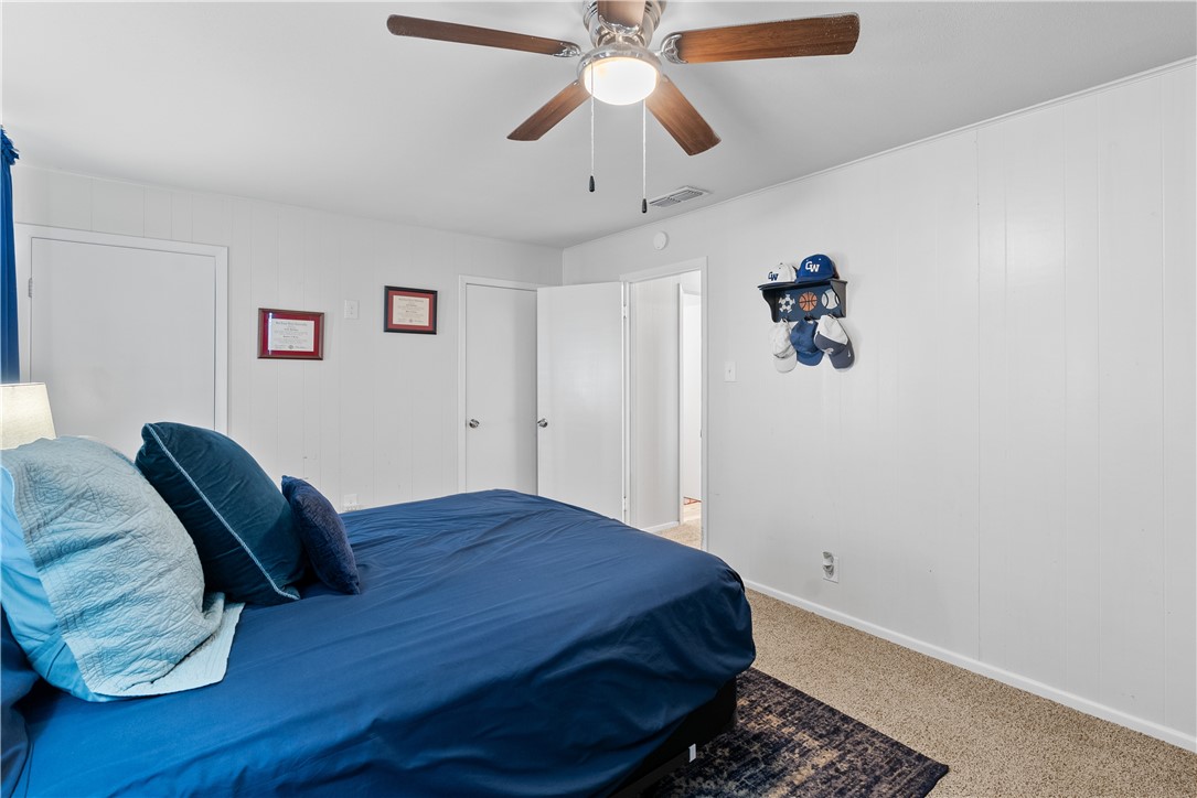 1204 Fannin Street George West, TX 78022 - Photo 15 of 24 a bedroom with a bed and a chandelier
