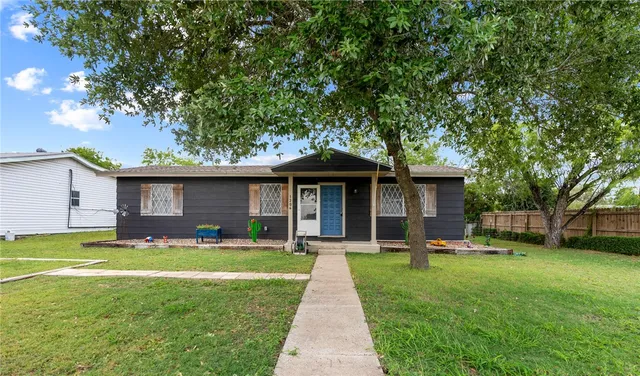 a view of a house with backyard and sitting area