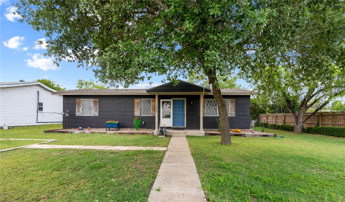 1204 Fannin Street George West, TX 78022 - Photo 19 of 24 a front view of a house with a garden and trees