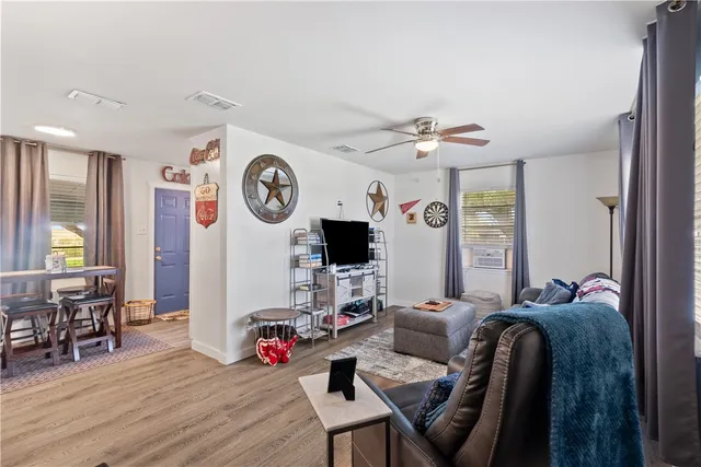 a living room with furniture a wooden floor and a clock