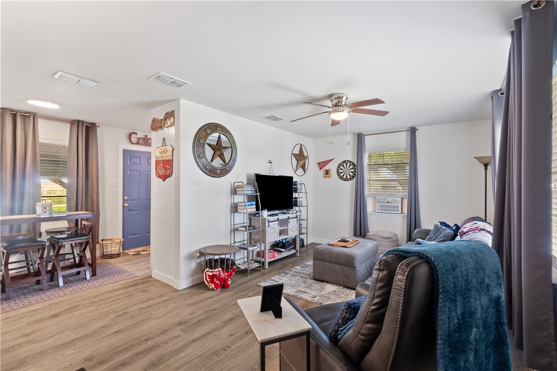 1204 Fannin Street George West, TX 78022 - Photo 2 of 24 a living room with furniture a wooden floor and a clock