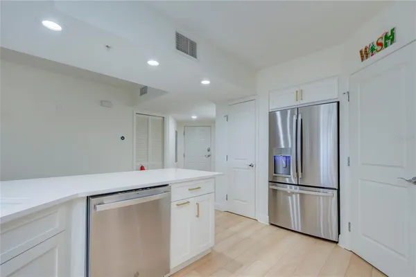 a kitchen with a refrigerator sink and cabinets
