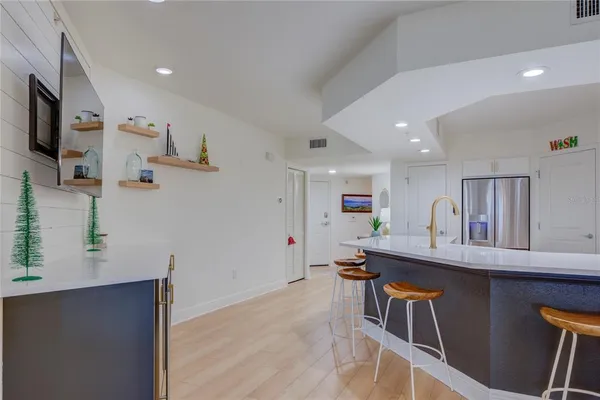 a room with stainless steel appliances kitchen island a table and chairs in it