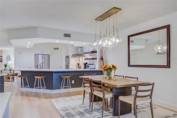 a view of a dining room with furniture a chandelier and wooden floor