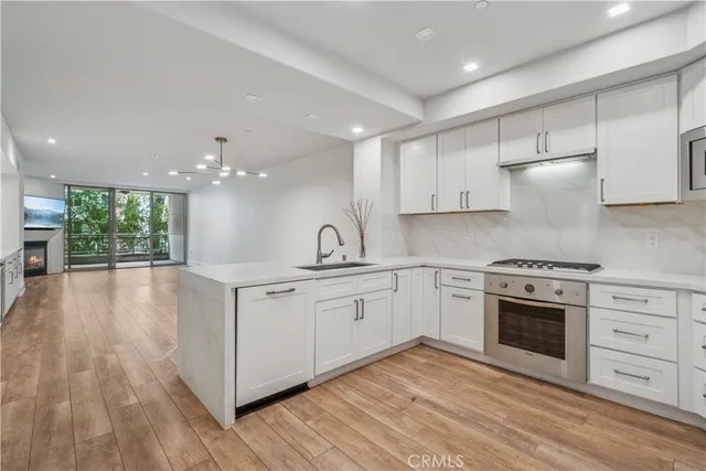 a kitchen with stainless steel appliances granite countertop a stove a sink and white cabinets