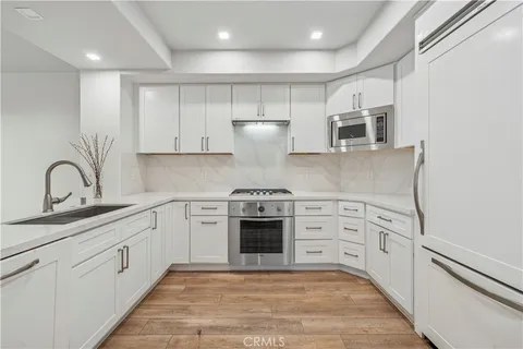 a kitchen with stainless steel appliances granite countertop a stove and white cabinets