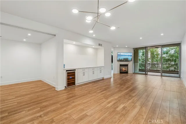 an empty room with wooden floor a ceiling fan and windows