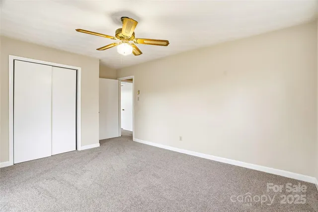 an empty room with a ceiling fan and a window