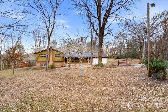 a view of a white house with a yard and tree