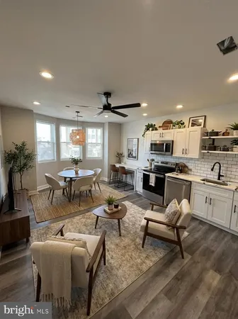 a living room with furniture kitchen view and a large window