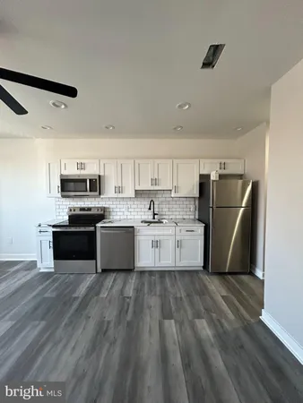 a large kitchen with cabinets and stainless steel appliances