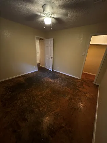 a view of an empty room with a chandelier fan