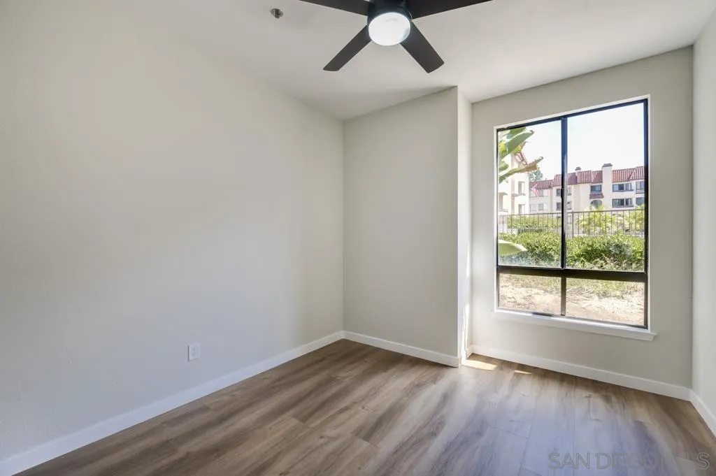 5845 Friars Road, Unit 1116 San Diego, CA 92110 - Photo 12 of 30 a view of an empty room with wooden floor and a window