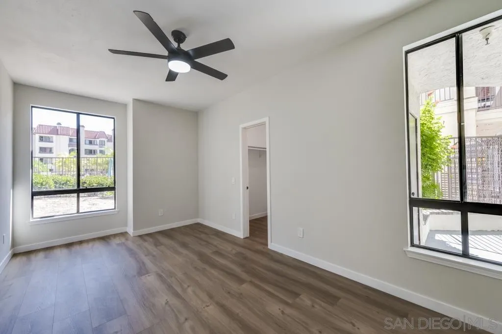 5845 Friars Road, Unit 1116 San Diego, CA 92110 - Photo 13 of 30 an empty room with wooden floor fan and windows