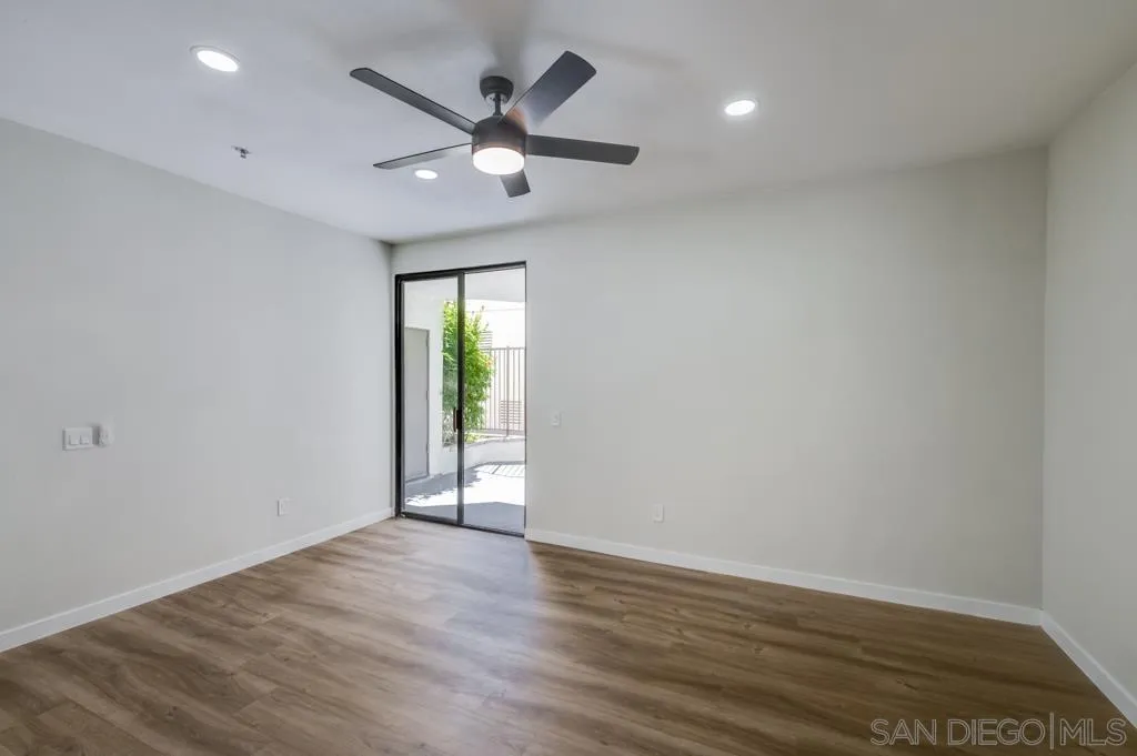 5845 Friars Road, Unit 1116 San Diego, CA 92110 - Photo 16 of 30 an empty room with wooden floor and windows