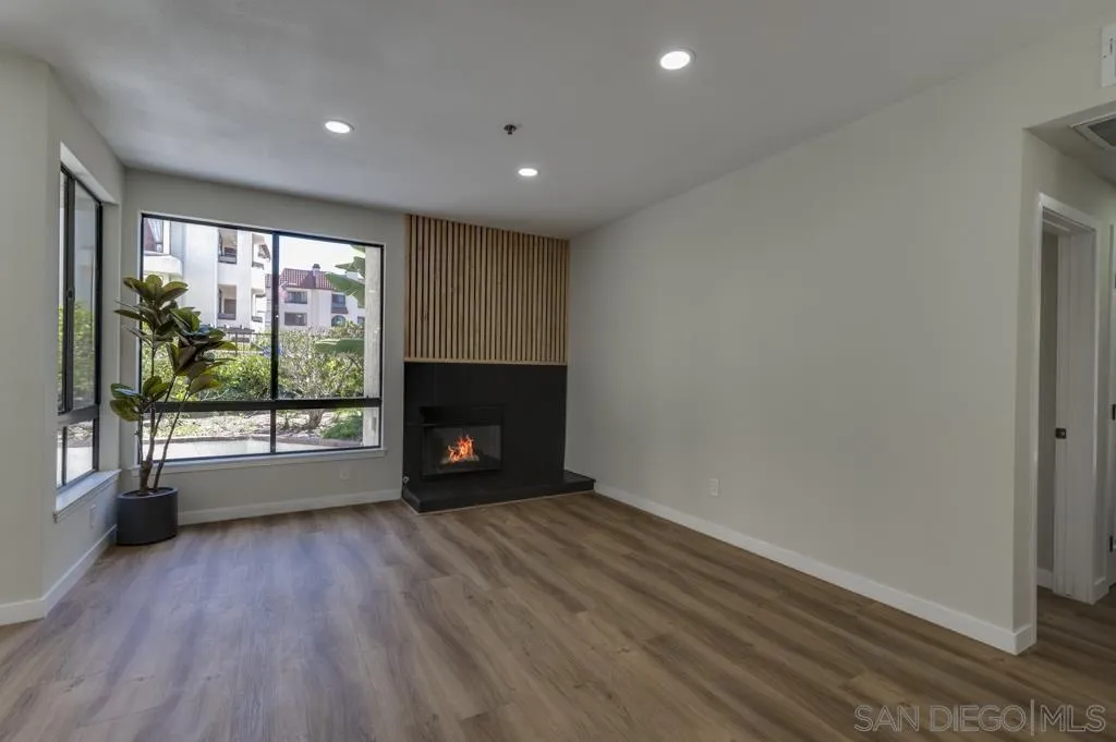 5845 Friars Road, Unit 1116 San Diego, CA 92110 - Photo 2 of 30 a view of empty room with wooden floor and fireplace