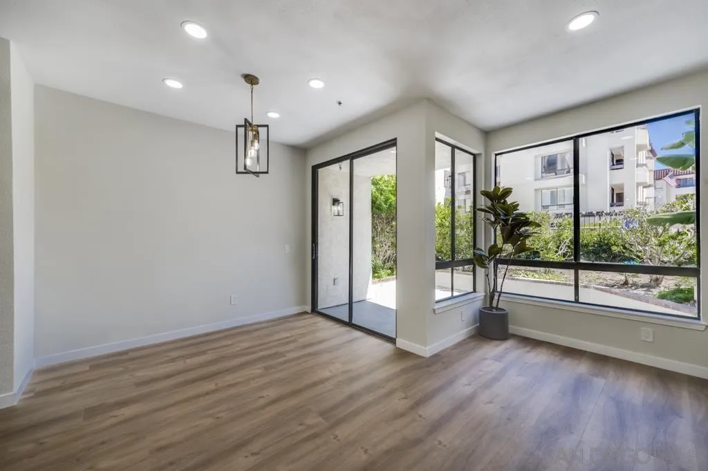 5845 Friars Road, Unit 1116 San Diego, CA 92110 - Photo 4 of 30 a view of an empty room with wooden floor and a window