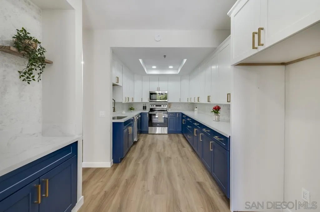 5845 Friars Road, Unit 1116 San Diego, CA 92110 - Photo 5 of 30 a kitchen with stainless steel appliances sink a microwave and cabinets