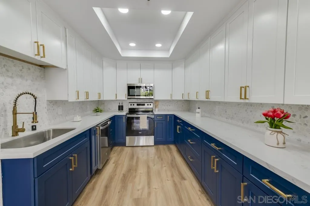 5845 Friars Road, Unit 1116 San Diego, CA 92110 - Photo 7 of 30 a kitchen with kitchen island granite countertop a sink stainless steel appliances cabinets and counter space