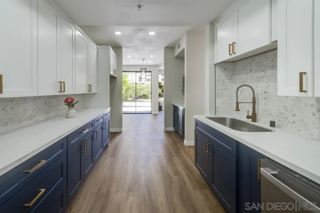 5845 Friars Road, Unit 1116 San Diego, CA 92110 - Photo 9 of 30 a kitchen with kitchen island granite countertop a sink stainless steel appliances and cabinets