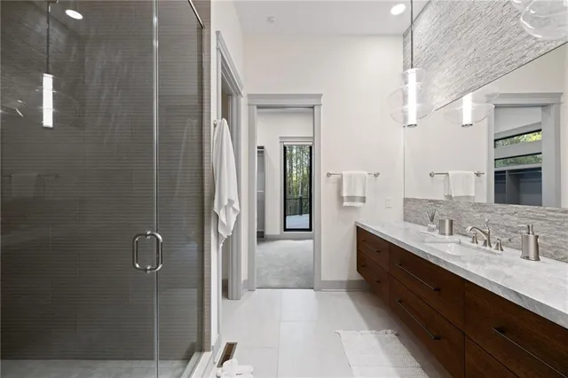 a en suite bathroom with a double vanity sink a large mirror and shower