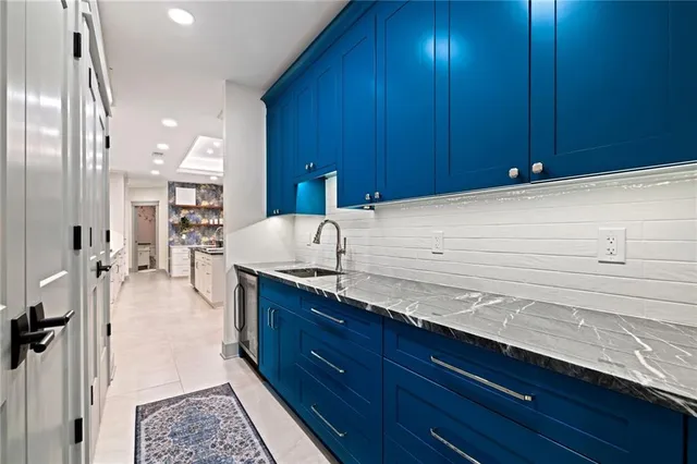 a large kitchen with granite countertop wooden cabinets and stainless steel appliances