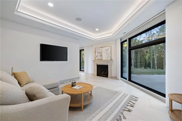 a living room with furniture a rug and a floor to ceiling window