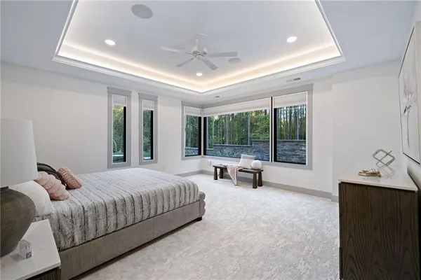 a bedroom with a bed and large windows