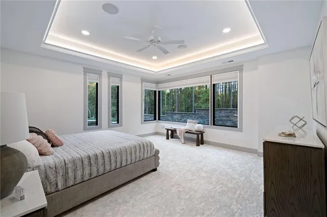 a bedroom with a bed and large windows