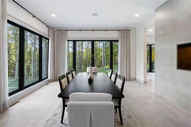 a dining room with furniture and a floor to ceiling window