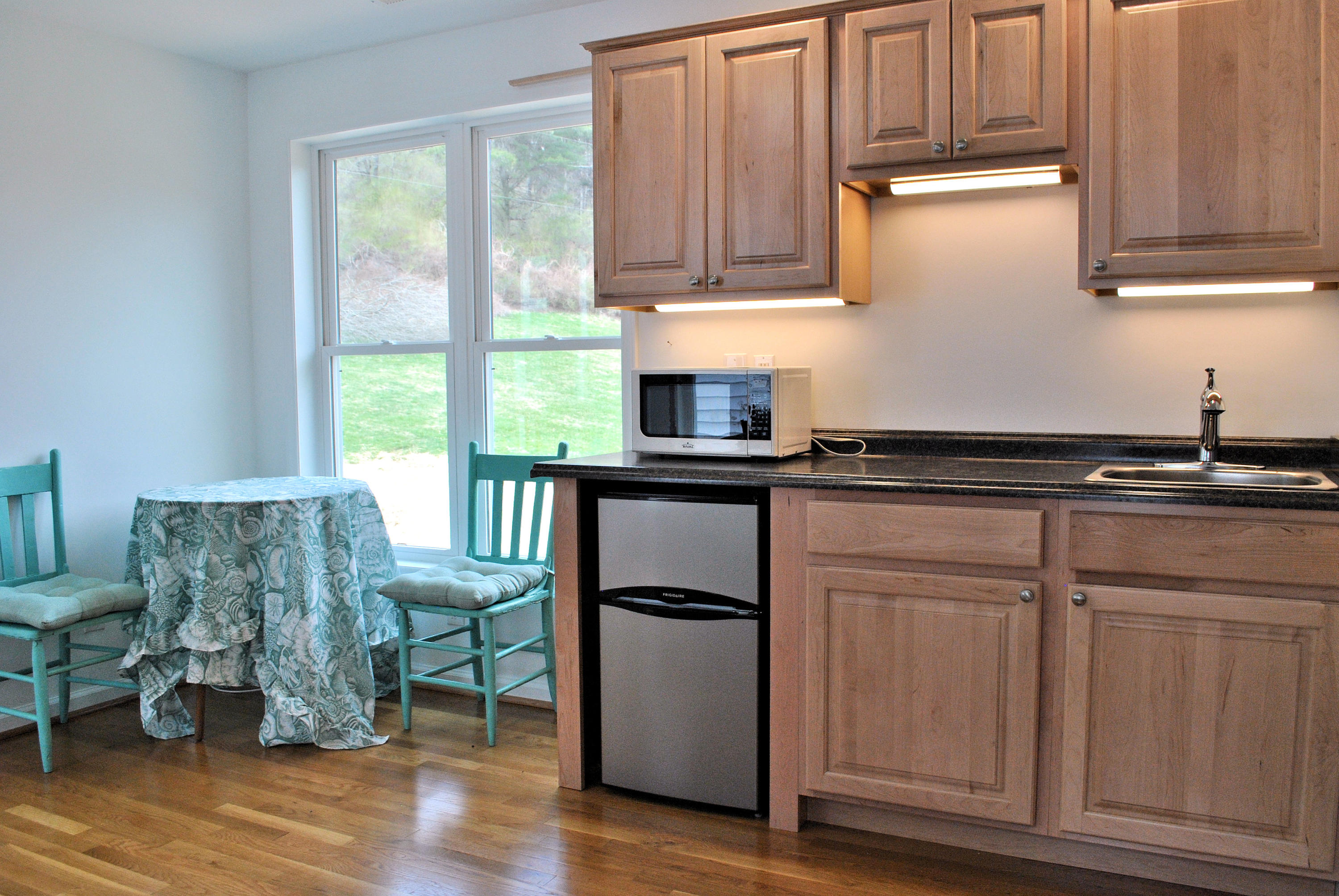6500 Little Camp Road Riner, VA 24149 - Photo 71 of 121 a kitchen with granite countertop a stove a sink and dishwasher with wooden floor