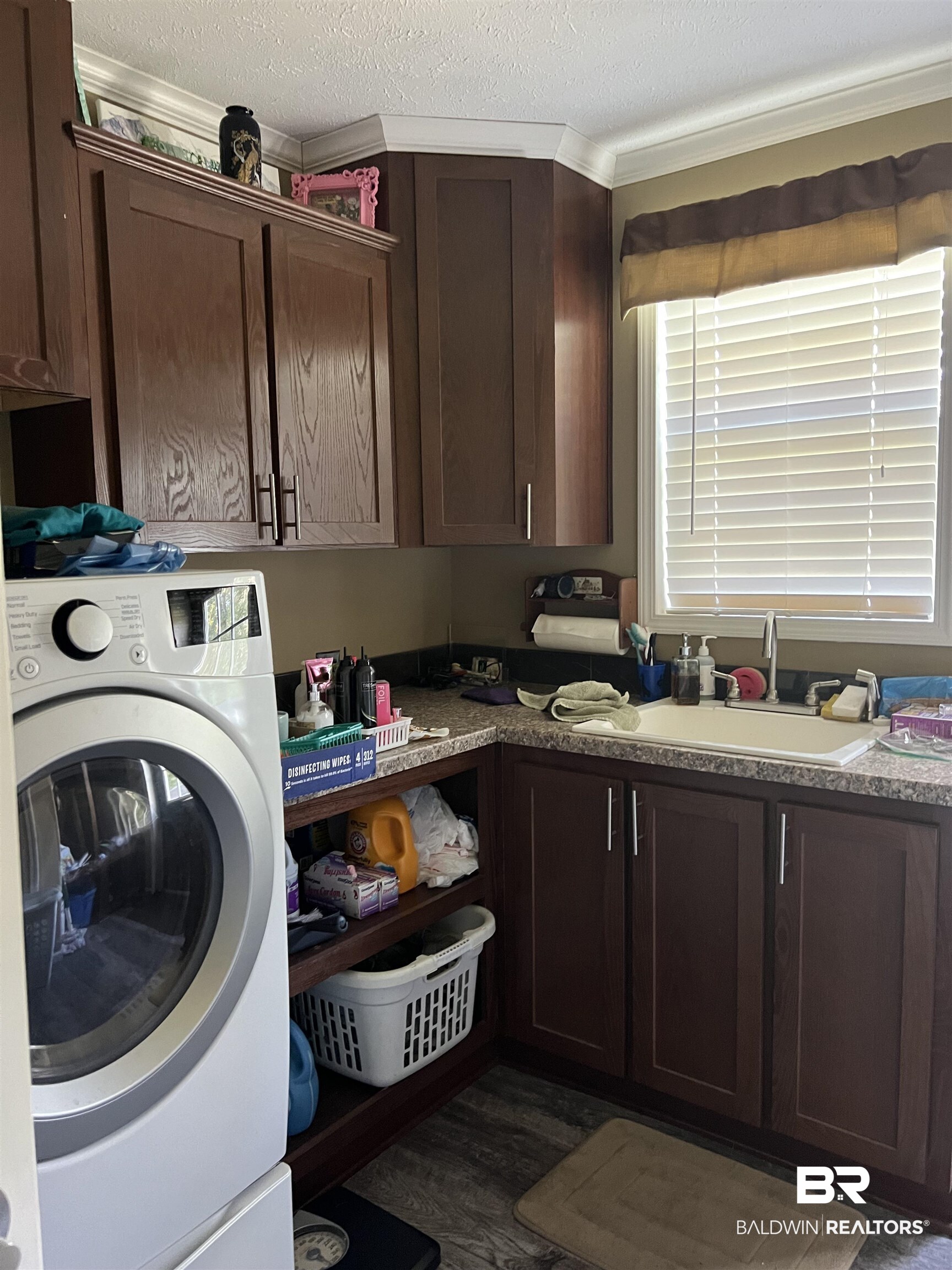 16824 Underwood Road Foley, AL 36535 - Photo 12 of 25 Laundry room featuring a textured ceiling, dark wood-type flooring, washer / clothes dryer, cabinets, and crown molding