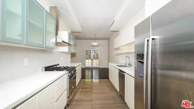 a kitchen with stainless steel appliances a sink stove and refrigerator