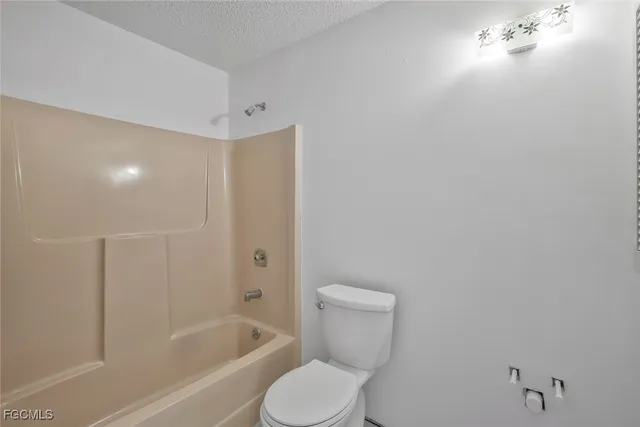 a white toilet sitting next to a bath tub