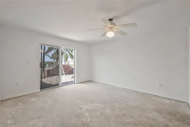 an empty room with fan and windows